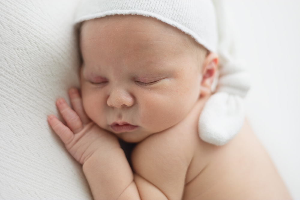 bébé endormi sur le ventre avec bonnet