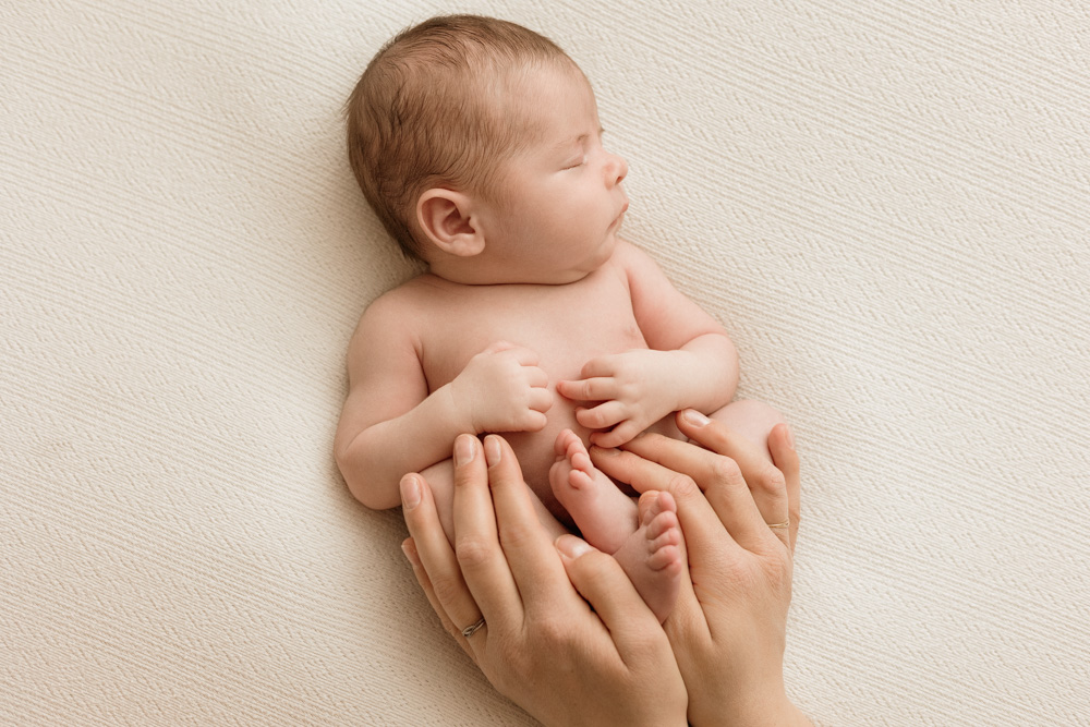 photo de bébé endormi avec les mains des parents à Tours