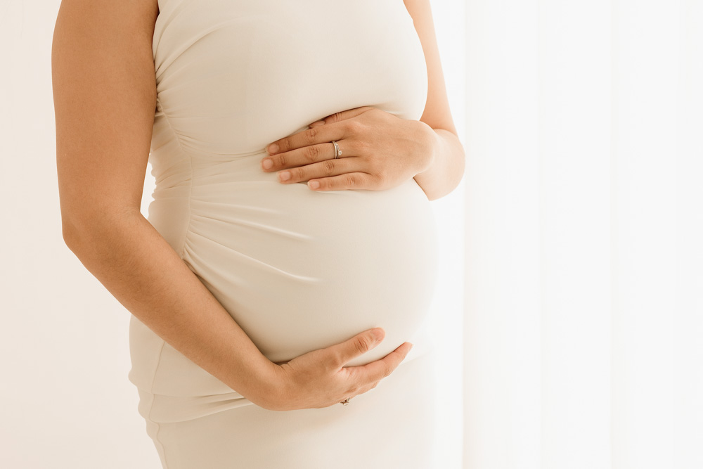 Geste tendre d’une future maman caressant son ventre à Tours