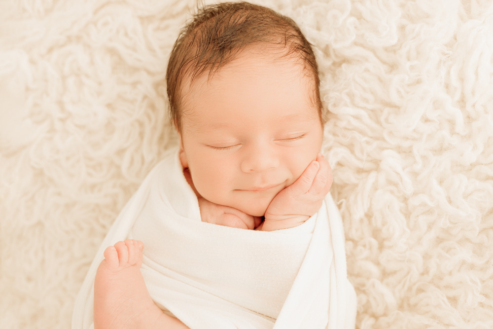 photographe naissance tours, emmaillotage de bébé sourire