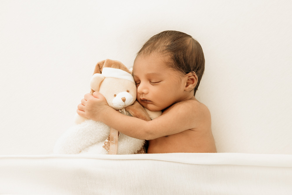 shooting photo naissance à tours, bébé endormi faisant un câlin à son doudou